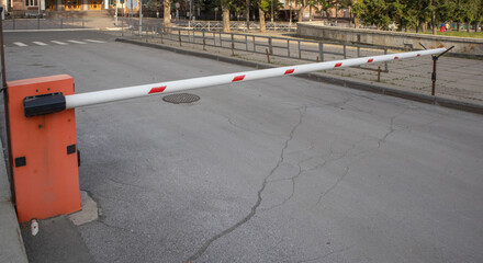 Red and white metal barrier, blocking the road, protecting the territory, controlling entry