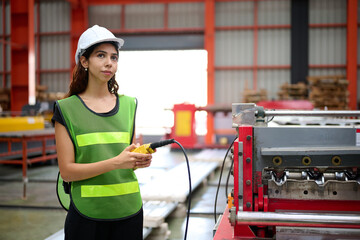 Engineer or worker operating remote switch to control machine in the factory