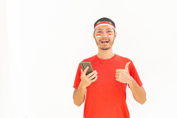 Young Indonesian man thumbs up to mobile phone with headband in isolated white