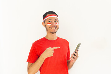 Young Indonesian man pointing to mobile phone with headband in isolated white
