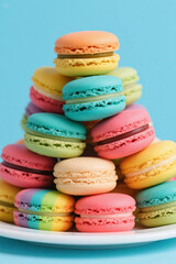Fototapeta premium Vibrant Rainbow Macarons Stacked in a Pyramid on a white Plate