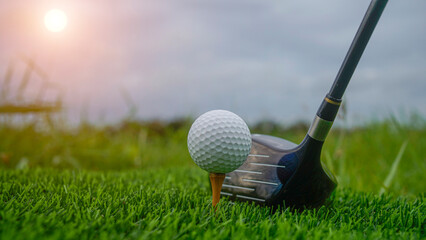 Golf clubs and balls on a green lawn in a beautiful golf course with morning sunshine.