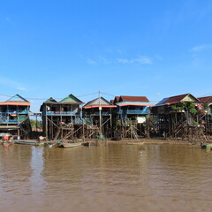 poor floating village in Cambodia, houses on stilts and lots of garbage