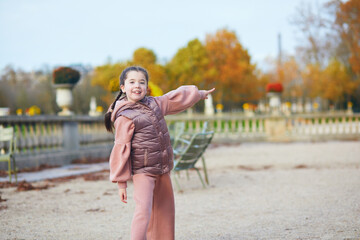 Adorable little girl having fun on a fall day in Luxembourg garden of Paris, France
