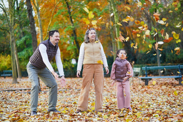 Naklejka premium Happy family of three, father, mother and daughter enjoying family time together in Luxembourg garden of Paris, France.