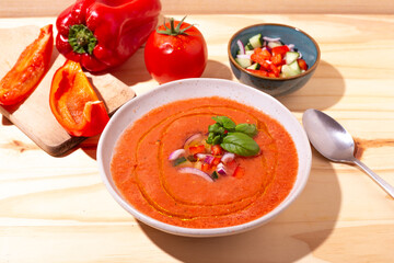 Fresh tomato and bell pepper gazpacho with basil and onion — overhead, natural light.