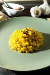 Saffron risotto in a rustic composition with garlic and parmesan cheese&ugrave;