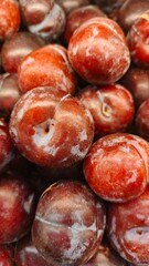 Close up pile of tasty fresh plums sold at the market as a background.