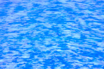 Obraz premium Abstract texture of moving blue water with dreamy reflections.