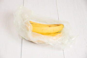 Spoiled bananas in a plastic bag on light background