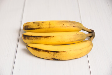 A branch of spoiled bananas on light background