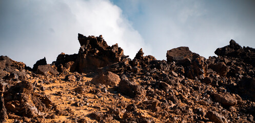 Volcanic landscape with basalt rocks, stones and sand, a volcano terrain at sunset.