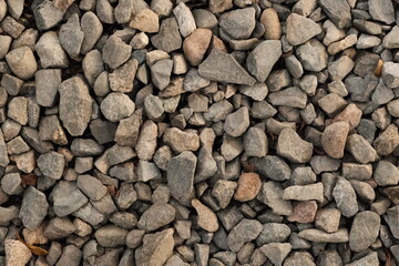 Close-up of gray gravel stones in natural light, showing texture and rough surfaces.