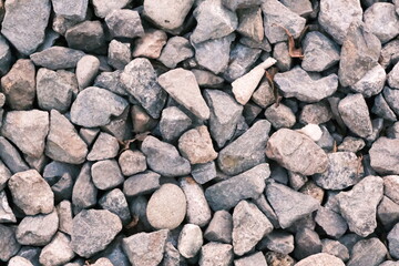 Close-up of gray gravel stones in natural light, showing texture and rough surfaces.