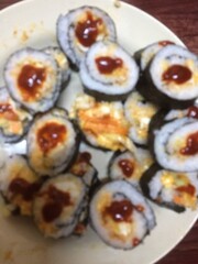 Defocused spicy sushi rolls with sauce topping