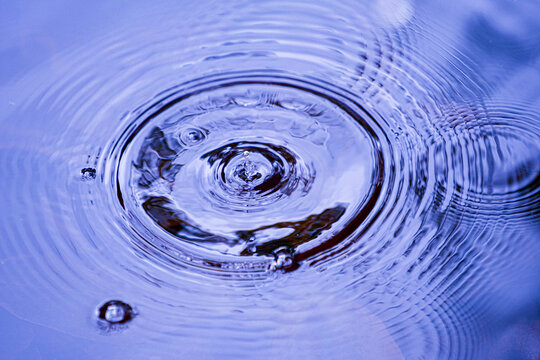 Raindrops falling on smooth surface of water. water droplets affect the surface.
