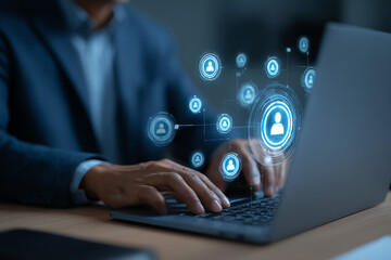 Person in a suit using a laptop with digital social network icons representing connections and interactions floating above the keyboard