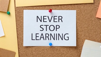 A white card pinned on a corkboard with colorful pins displays the motivational message "NEVER STOP LEARNING.