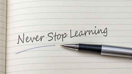 A pen rests on lined paper with the handwritten motivational phrase "Never Stop Learning" underlined.