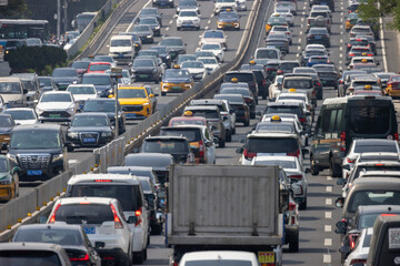 Heavy traffic congestion on a multi-lane highway with numerous vehicles and a central divider.