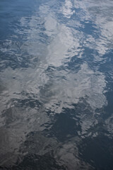 Close-up of the water with water reflection of clouds of the pool in a public park. Clear water with sky and clouds reflection. Water reflection. Nature scene.