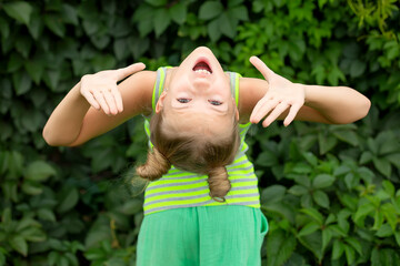 Joyful Girl Smiling Upside Down with Arms Raised