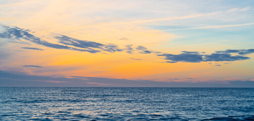 Fototapeta premium A Serene Sunset Over Coastal Waves, Beautifully Reflecting the Colors of the Sky