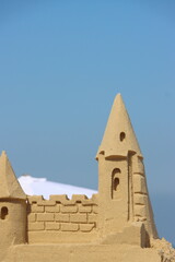 Sandcastle on the beach with umbrella and blue sky in the background,Ashqelon,Israel.