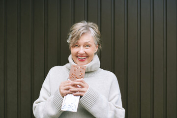 Portrait of happy laughing mature woman with big chocolate