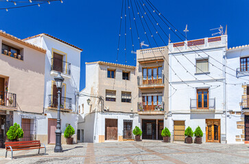 Old town Calpe city historical centre with typical white houses colorful traditional buildings on small square Villa Plaza in sunny summer day, province of Alicante, Valencian Community, Spain