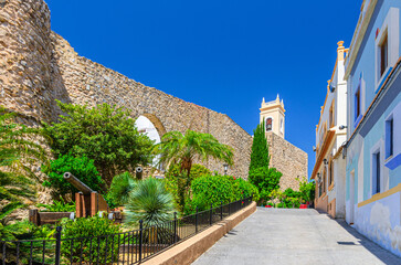 Torreo de la Peca tower and Museum of Collecting Museu del Coleccionisme building with stone walls in old town Calpe city historic centre in sunny day, Calp Casco Antiguo, Valencian Community, Spain