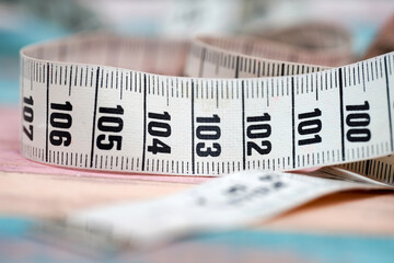 Measuring tape lies on fabric with marked measurements, showcasing precision and craftsmanship in sewing or design activity
