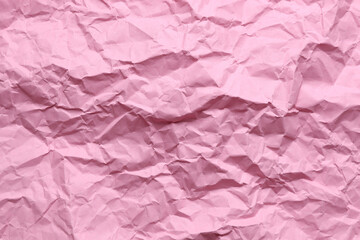 Crumpled pink paper background texture close up