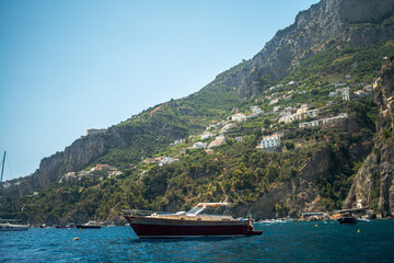 Obraz premium A breathtaking view of the Amalfi Coast showcasing dramatic cliffs, crystal-clear blue waters, and charming coastal architecture.