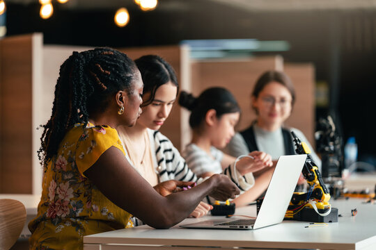 STEM Education Class With Teacher Guiding Diverse Students to Code and Build Robotic Arm Using Computers in Hands-On Engineering Activity