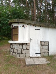 Small White Forest Hut with Stone Base