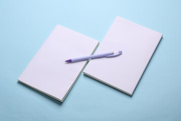 Magazines, sketchbooks or notebooks with white blank covers on blue background. Mockup for design