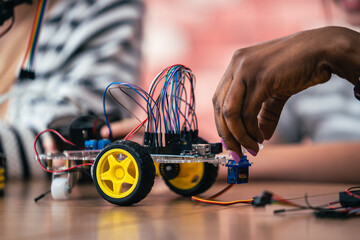 STEM Education Close-Up on Hand Connecting Circuit for Obstacle Avoiding Robot With Wires and...
