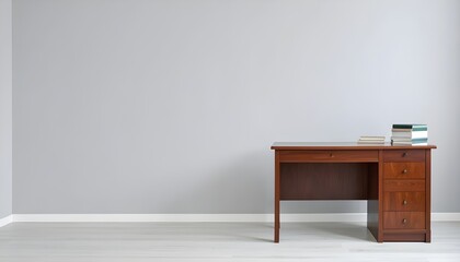 Minimalist workspace interior with a vintage wooden desk, books, and a clean gray wall. Perfect for design, work, or study themes with natural light and empty copy space.