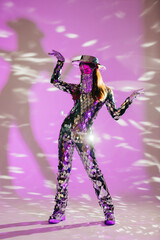 Mirror dancer performing in a purple studio with hat and face mask