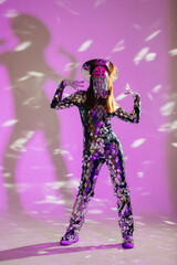 Mirror dancer performing in purple light with reflecting costume