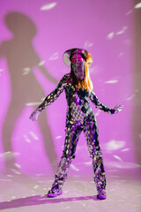 Mirror dancer performing in a purple studio with creative lighting