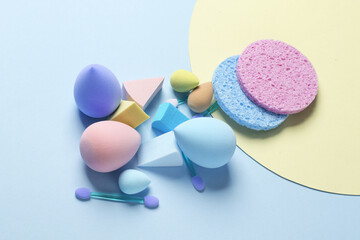 Make-up sponge, cosmetic blenders and applicators for makeup on blue background. Beauty products.