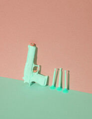 Toy plastic gun on a blue-pink pastel background. Minimalism, creative layout