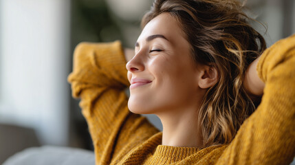 A young woman in a yellow sweater relaxes with her hands behind her head, smiling peacefully with her eyes closed.