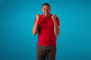 Fototapeta premium Adult short-haired man wearing a red shirt in studio shots with various facial expressions and expressing mixed feelings