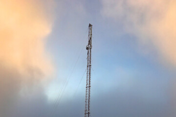 Obraz premium Tall Communication Tower Against Dramatic Sunset Sky