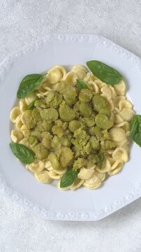 Orecchiette pasta with fava beans and basil.  A classic Italian dish called pasta e fave or pasta con fave. Vertical video.
