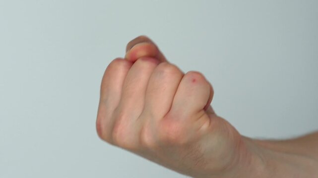 Male fist and gesture of aggression.
Man provokes aggressive behavior.
Fisting with hand on white background.
Man imitates punching with fist.
Domestic violence and conflicts in family