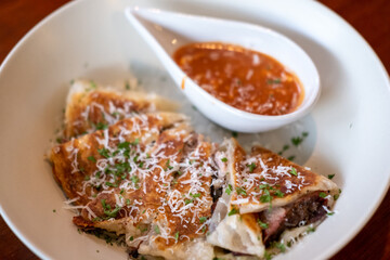 Roti quesadillas filled with smoked pulled pork with mozzarella cheese on top, served with mustard bbq sauce.